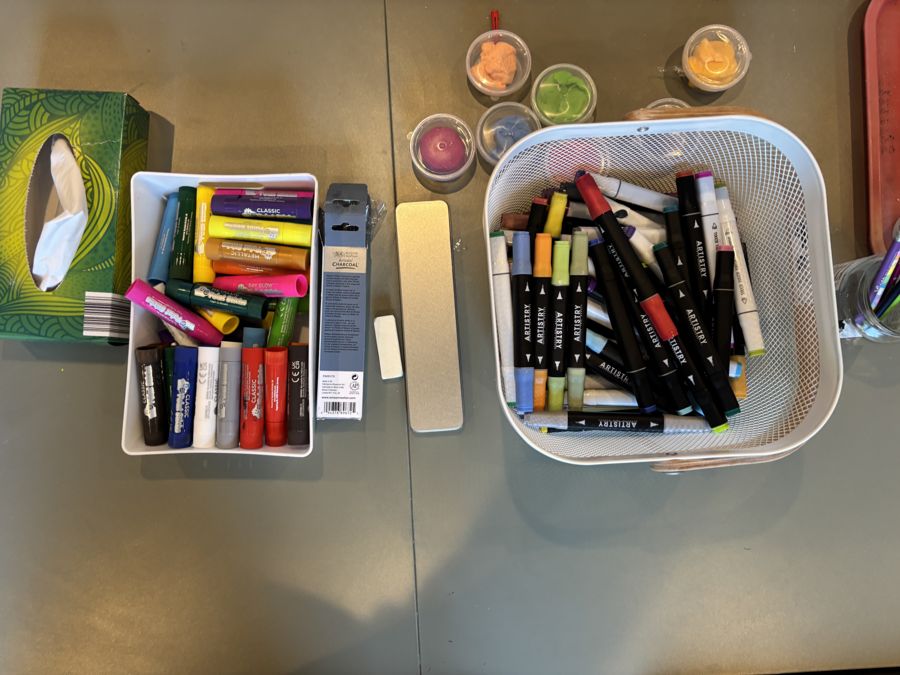 Paint sticks, markers and modelling clay laid out