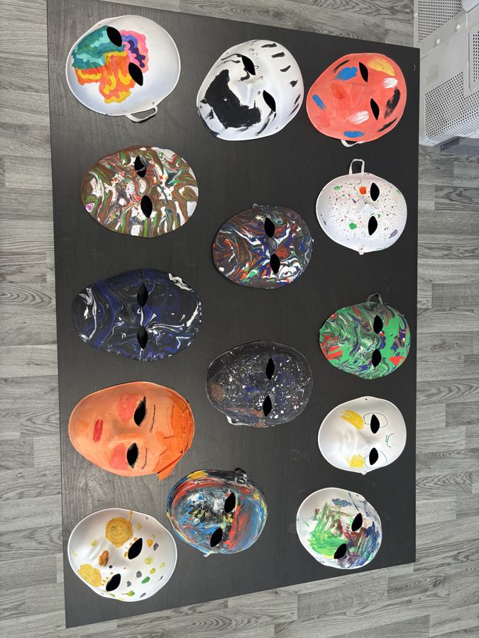A collection of painted masks laid out on a table